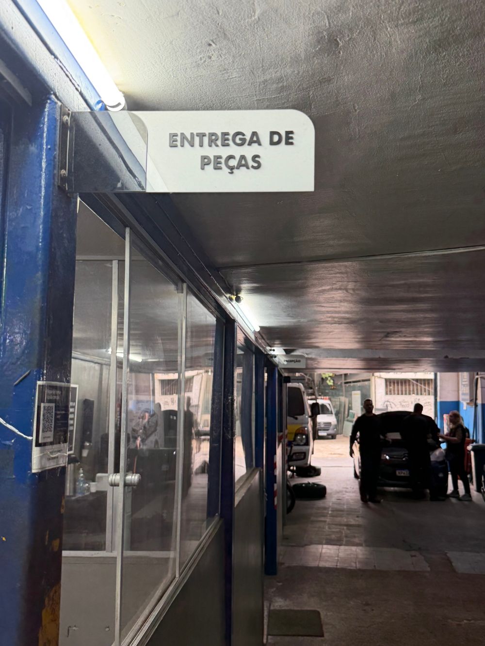 Corredor da oficina com a placa Entrega de Peças